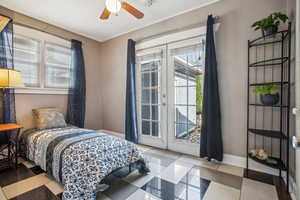 Bedroom featuring french doors, multiple windows, light tile patterned flooring, and access to exterior