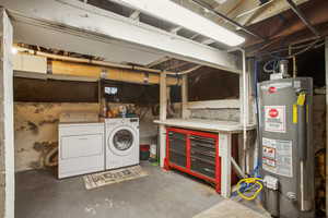 Unfinished basement featuring gas water heater and washing machine and clothes dryer