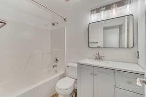 Full bathroom with toilet, tub / shower combination, and vanity