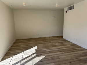 Spare room with baseboards, visible vents, wood finished floors, and recessed lighting