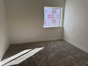 Unfurnished room featuring carpet and baseboards