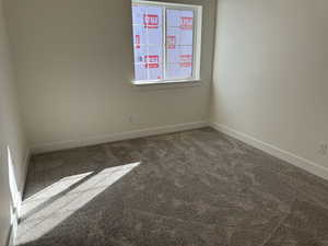 Carpeted spare room with baseboards