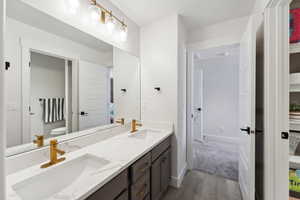 Full bathroom featuring double vanity, toilet, and a sink