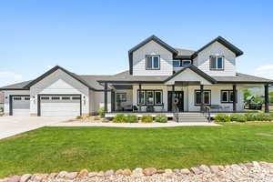 Modern inspired farmhouse featuring covered porch, a front yard, a garage, concrete driveway, and a shingled roof