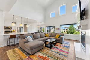 Living area featuring dark wood-style floors, a fireplace, and a chandelier