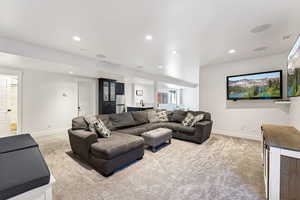 Living room with light carpet, visible vents, and baseboards