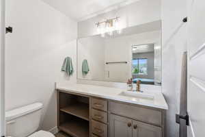 Ensuite bathroom featuring toilet, vanity, and ensuite bathroom