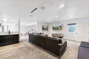 Living area featuring baseboards, light wood-type flooring, visible vents, and recessed lighting