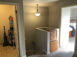 Corridor featuring light carpet and an upstairs landing