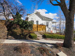 View of front facade featuring a chimney and stucco siding