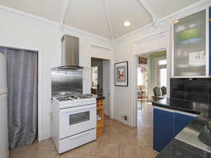 Kitchen featuring visible vents, dark countertops, range hood, white gas stove, and backsplash