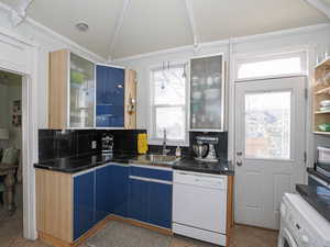 Kitchen featuring dishwasher, washer / clothes dryer, plenty of natural light, and a sink