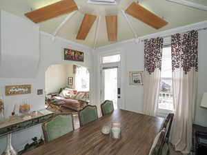 Dining space with arched walkways, high vaulted ceiling, and a healthy amount of sunlight