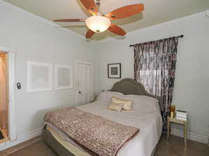 Bedroom with baseboards, a ceiling fan, and crown molding