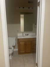 Bathroom featuring toilet, vanity, and tile patterned flooring