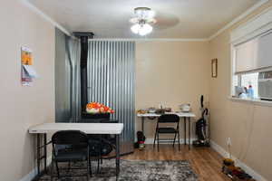 Office with dark wood-type flooring, ornamental molding, and baseboards