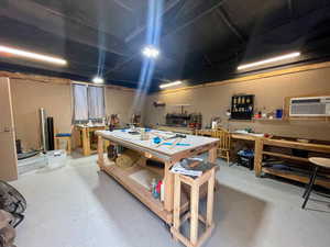 Below grade area featuring a wall mounted air conditioner and a workshop area