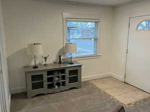 Entrance foyer featuring ornamental molding, baseboards, and light tile patterned floors