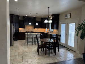 Dining area featuring recessed lighting, stone tile flooring, visible vents, an inviting chandelier, and baseboards