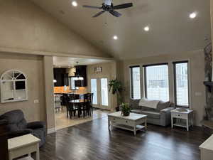 Living room featuring baseboards, dark wood-style floors, ceiling fan, high vaulted ceiling, and recessed lighting