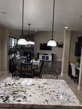 Kitchen featuring pendant lighting, light countertops, a fireplace, and visible vents