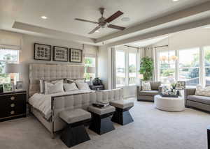 Bedroom featuring light carpet, a raised ceiling, and recessed lighting