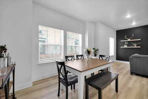 Dining area featuring light wood-style flooring and baseboards