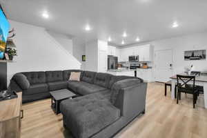 Living area with light wood-style flooring and recessed lighting