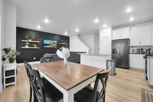 Dining area with light wood-style floors, recessed lighting, and baseboards