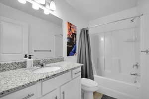 Bathroom with shower / bath combo, vanity, and toilet