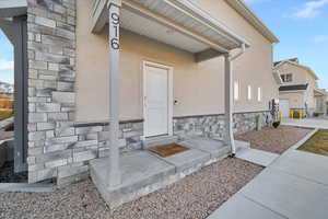 Doorway to property with stone siding and stucco siding