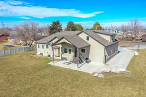 Back of property featuring a lawn, a residential view, fence, a patio area, and stucco siding