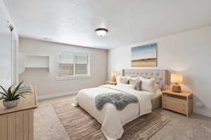 Bedroom with baseboards, visible vents, a textured ceiling, and light colored carpet