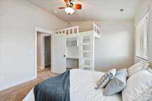 Bedroom with visible vents, baseboards, vaulted ceiling, and light colored carpet