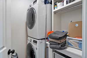 Laundry room with stacked washer and clothes dryer and laundry area