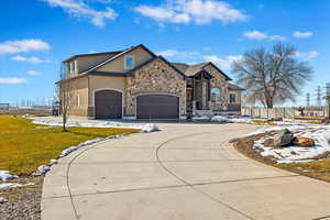 View of front facade with driveway, an attached garage, a front yard, and stucco siding