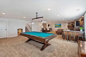 Playroom featuring light carpet, billiards, arched walkways, and indoor wet bar