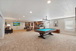 Playroom with light carpet, a fireplace, and baseboards