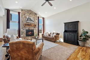 Living area featuring a fireplace, wood finished floors, and a wealth of natural light