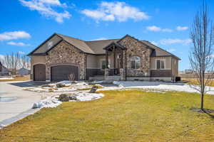 View of front of property featuring driveway, a front lawn, and an attached garage