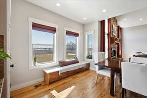 Interior space with recessed lighting, visible vents, a stone fireplace, light wood-type flooring, and baseboards