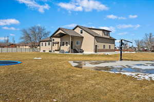 View of yard with basketball court and fence