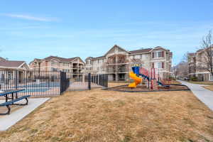 Community playground with a yard and community pool