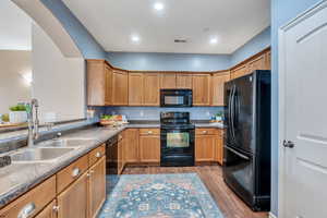 Kitchen featuring light wood-style flooring, black appliances, a sink, and recessed lighting