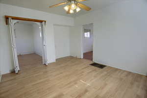 Unfurnished room featuring light wood finished floors, and a ceiling fan