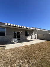 Rear view of house with a patio, a yard, and fence