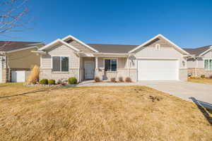 Craftsman inspired home featuring board and batten siding, concrete driveway, a front yard, a garage, and brick siding