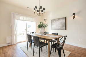 Dining room featuring visible vents, baseboards, and wood finished floors