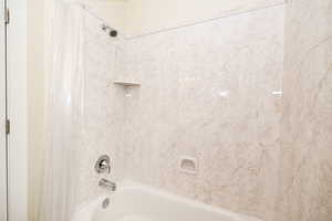 Full bathroom with shower / bath combination with curtain