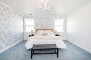 Carpeted bedroom with wallpapered walls, crown molding, and baseboards